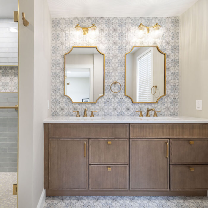 Double vanity with patterned tile and gold fixtures