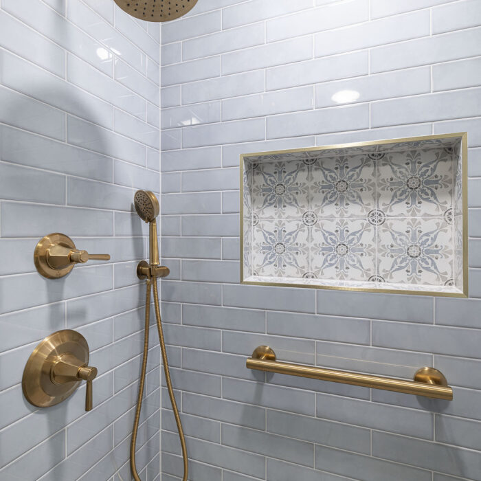 Modern shower with brass fixtures and subway tile