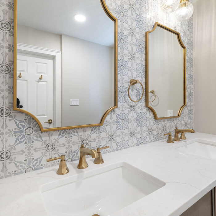 Elegant bathroom vanity with gold mirrors and faucets