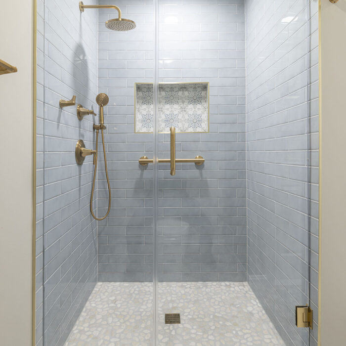 Glass shower with brass fixtures and niche
