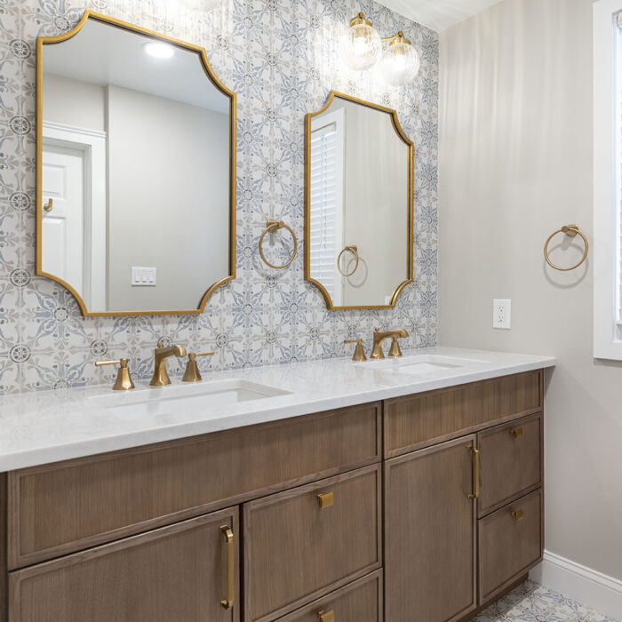 Double vanity bathroom with gold-framed mirrors