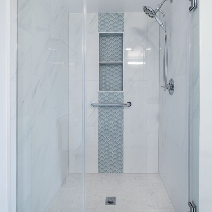 Contemporary glass shower with textured tile niche