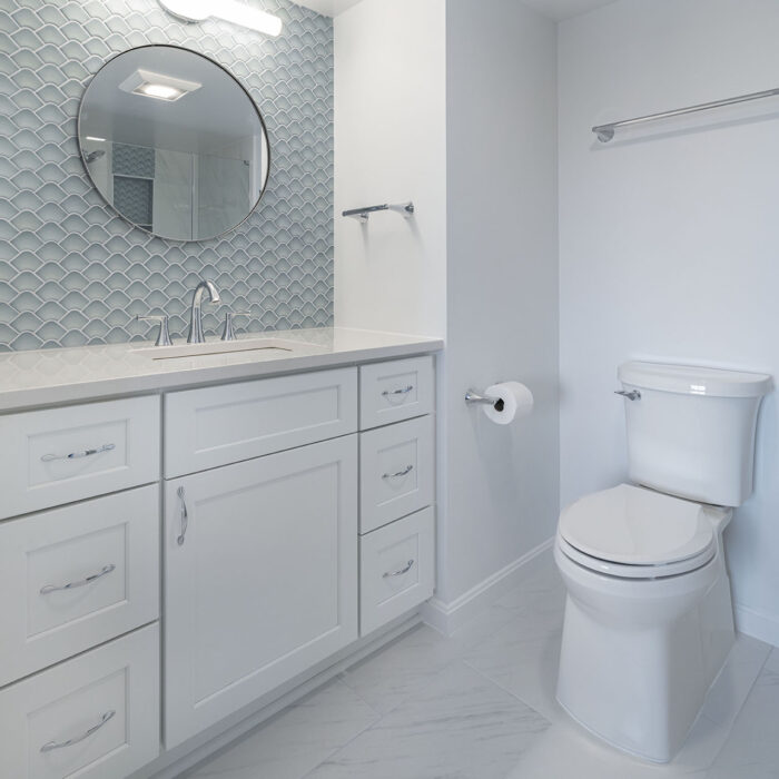 White bathroom vanity with round mirror