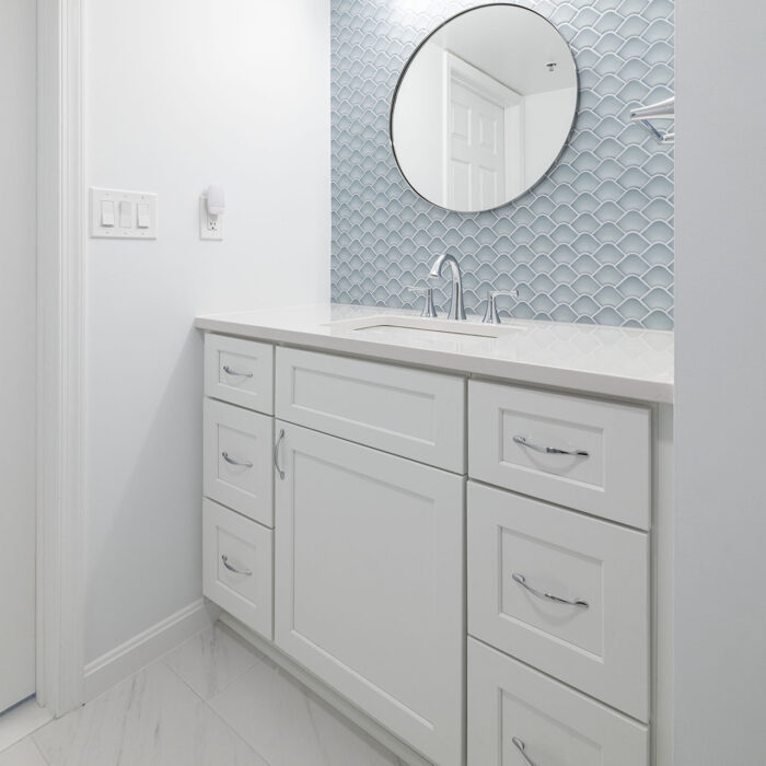 White bathroom vanity with blue fish scale backsplash