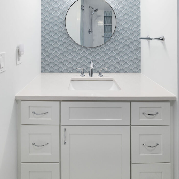 White bathroom vanity with blue tile backsplash