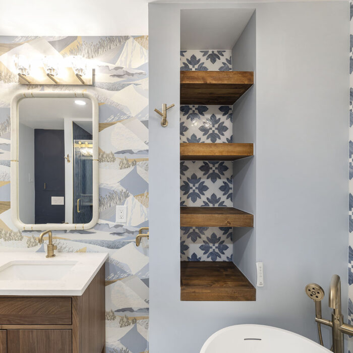 Bathroom with patterned wallpaper, mirrors, wood shelves