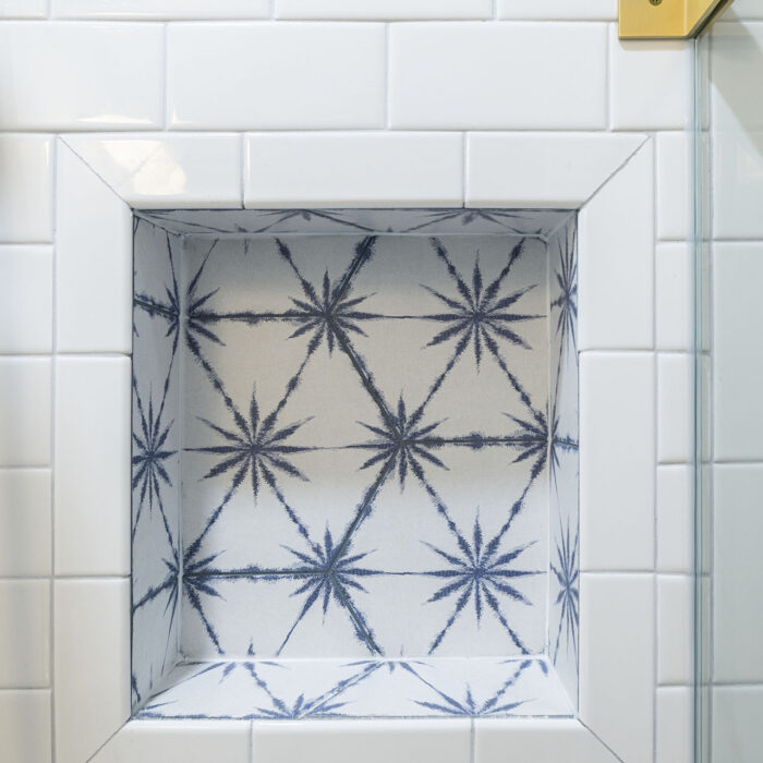 Shower niche with blue starburst patterned tiles
