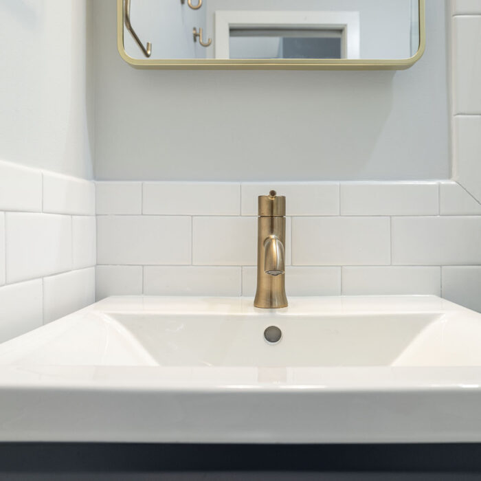 White bathroom sink with brass faucet