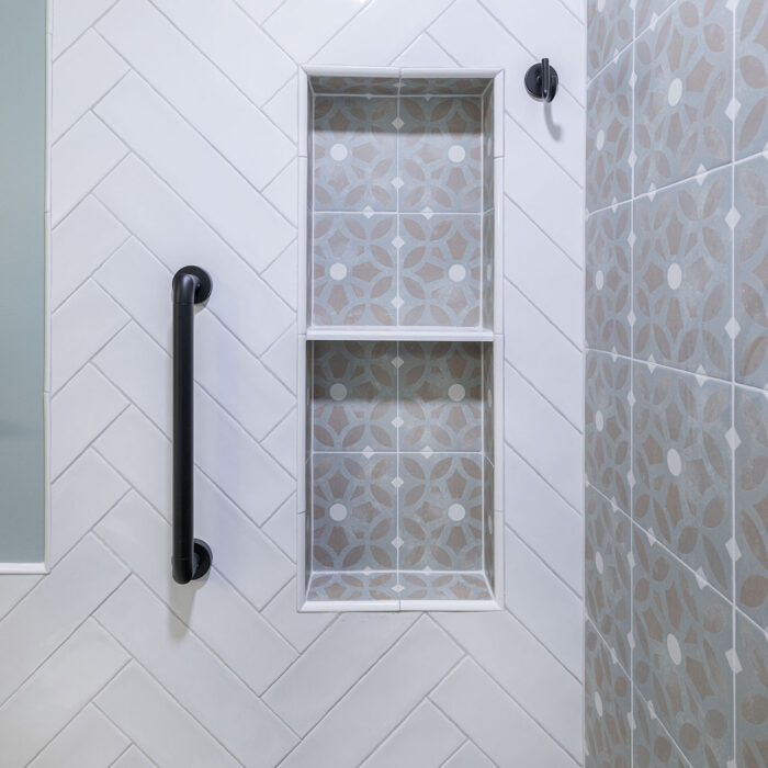 Shower niche with patterned tiles and grab bar