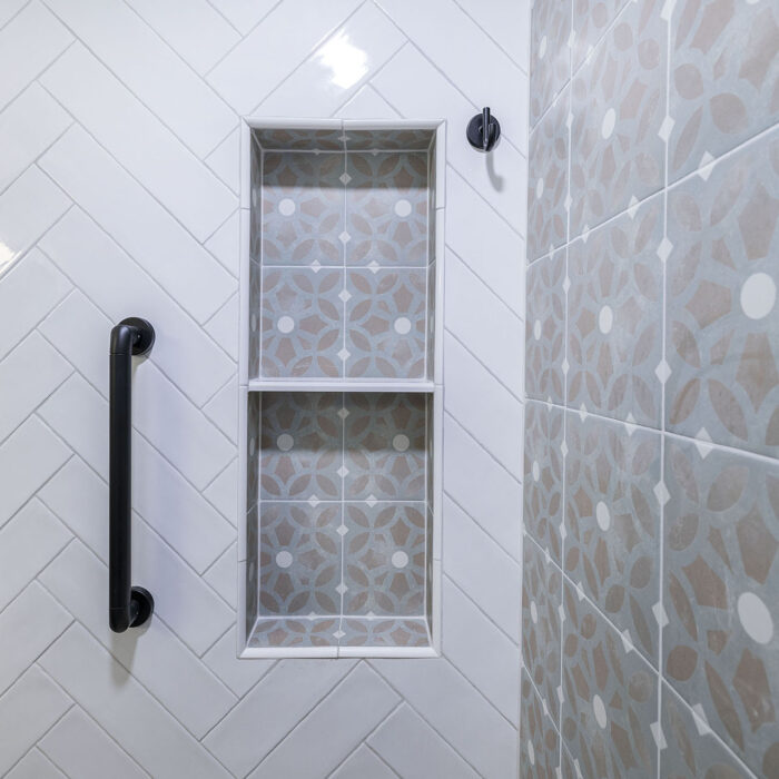 Shower niche with patterned tiles and grab bar
