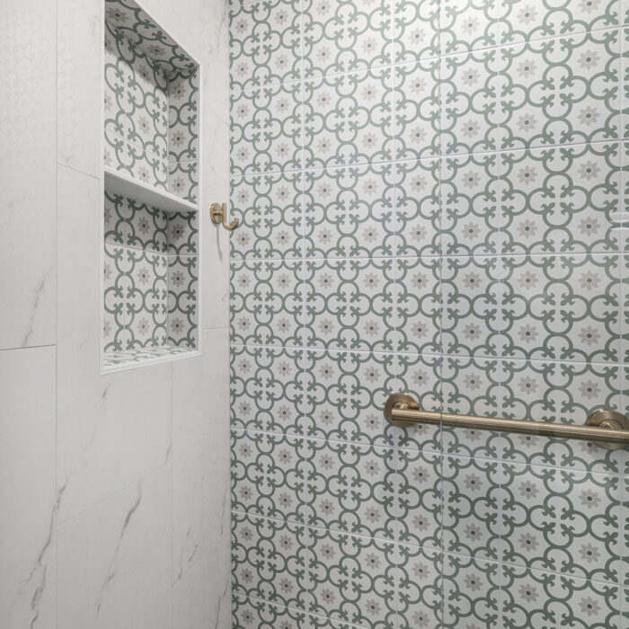 Patterned tiled shower with brass grab bar