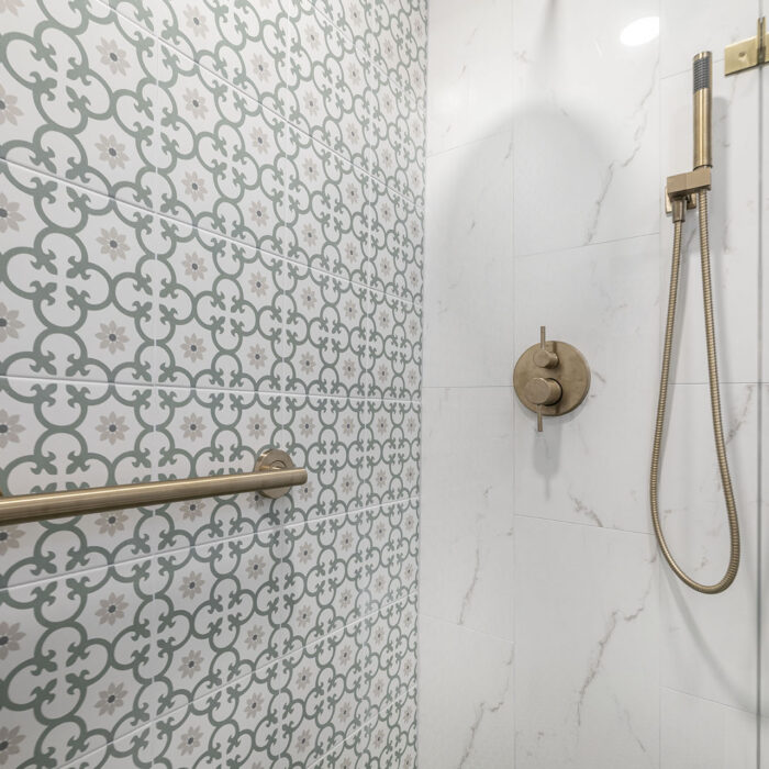 Brass rain shower and patterned tile walls