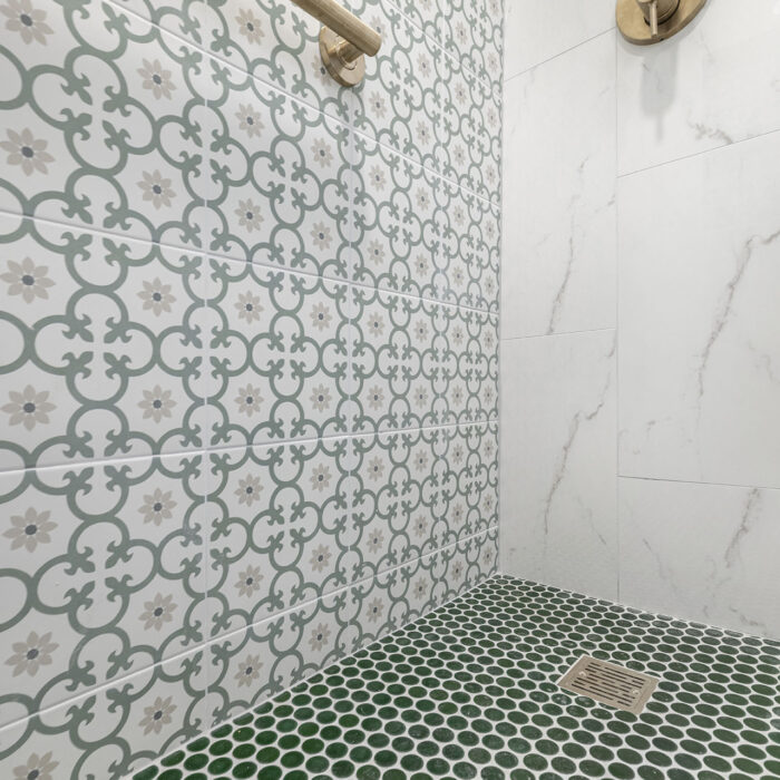 Patterned tiled shower with green penny floor