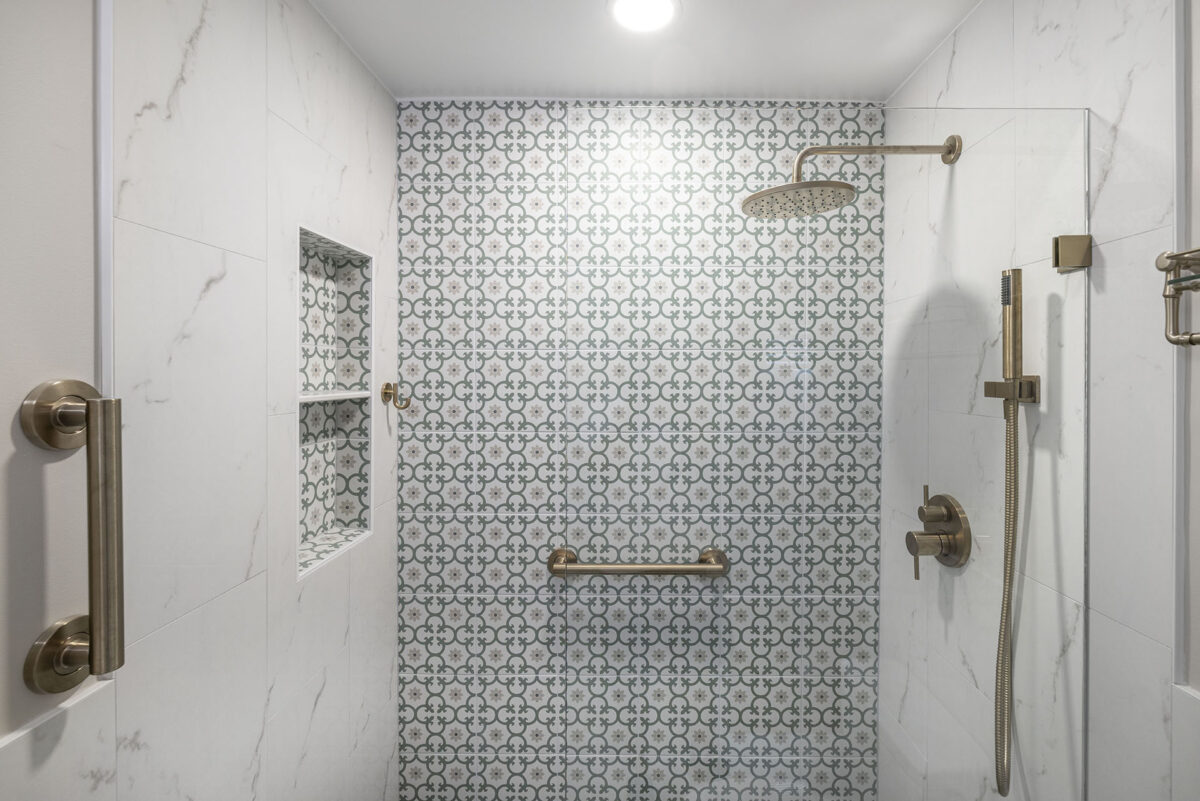 Modern shower with patterned tile and brass fixtures