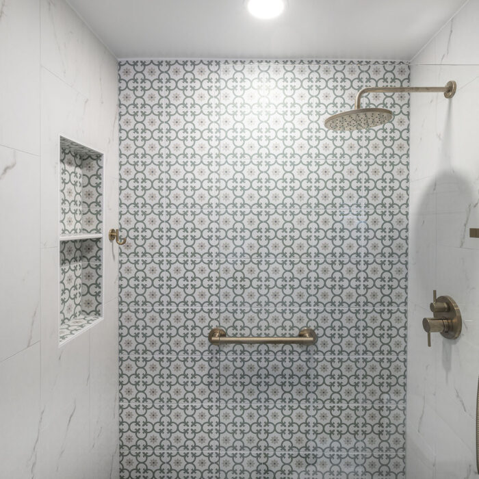 Modern shower with patterned tile and brass fixtures