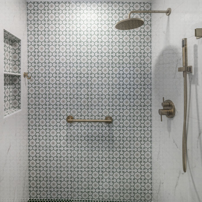 Modern shower with patterned tile and brass fixtures