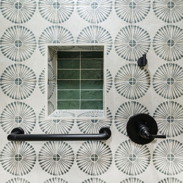 Decorative tiled shower wall with green niche