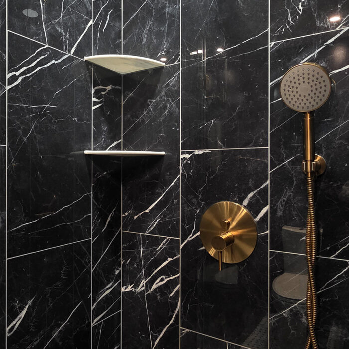 Black marble shower with gold fixtures
