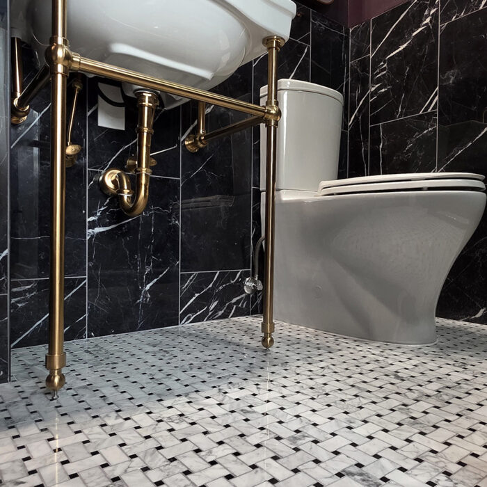 Modern bathroom with brass-legged sink and toilet