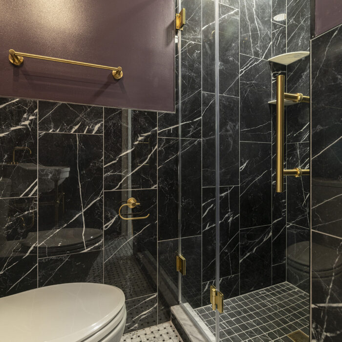 Black marble shower with gold fixtures