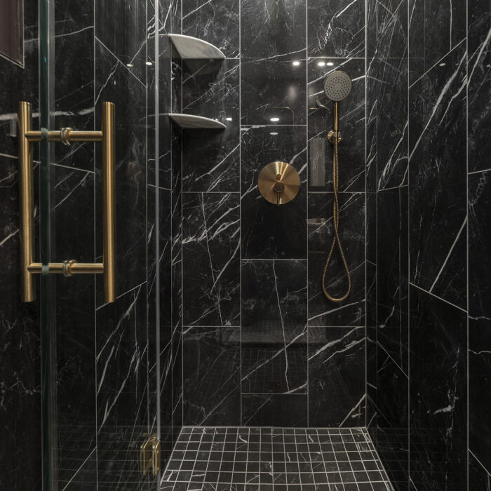 Black marble shower with gold fixtures