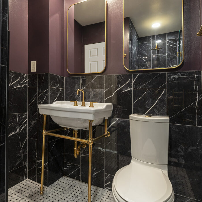 Bathroom with gold fixtures and black marble