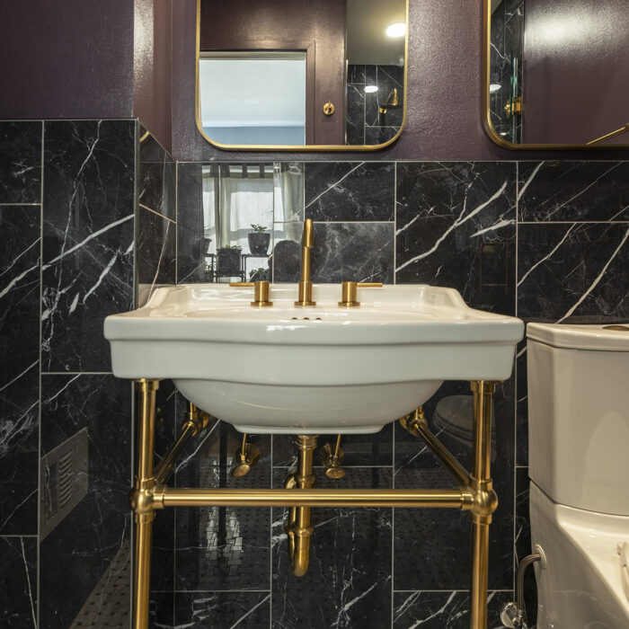 Sink with gold fixtures and black marble